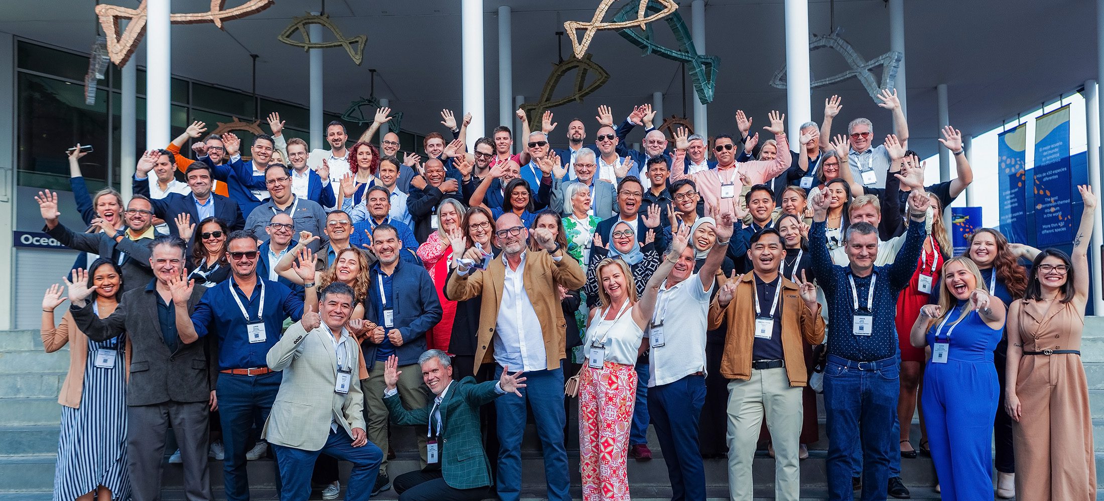 International attendees posing for a group photo during the Mobius corporate event at Barcelona Aquarium.