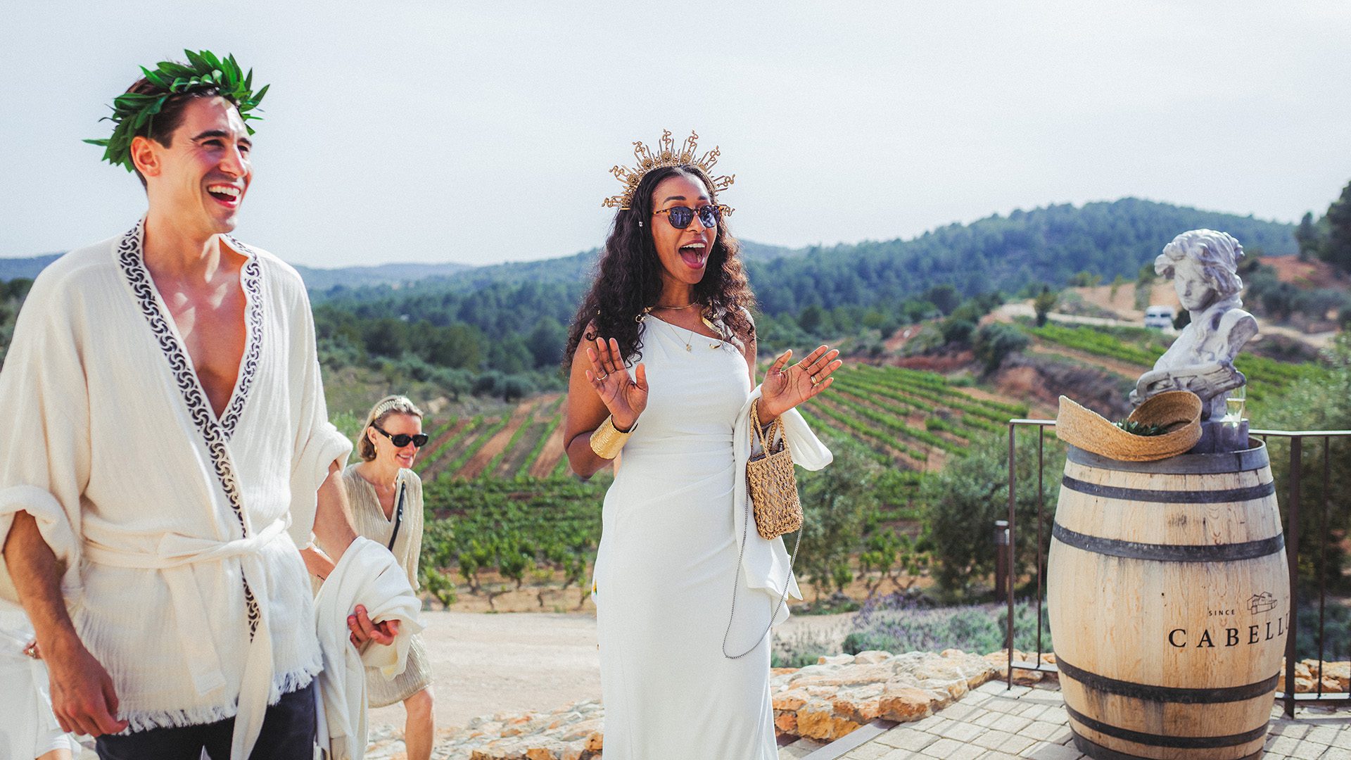 Guests arriving at a Greek-themed birthday celebration overlooking the vineyards of Masia Cabellut in Tarragona, Spain.