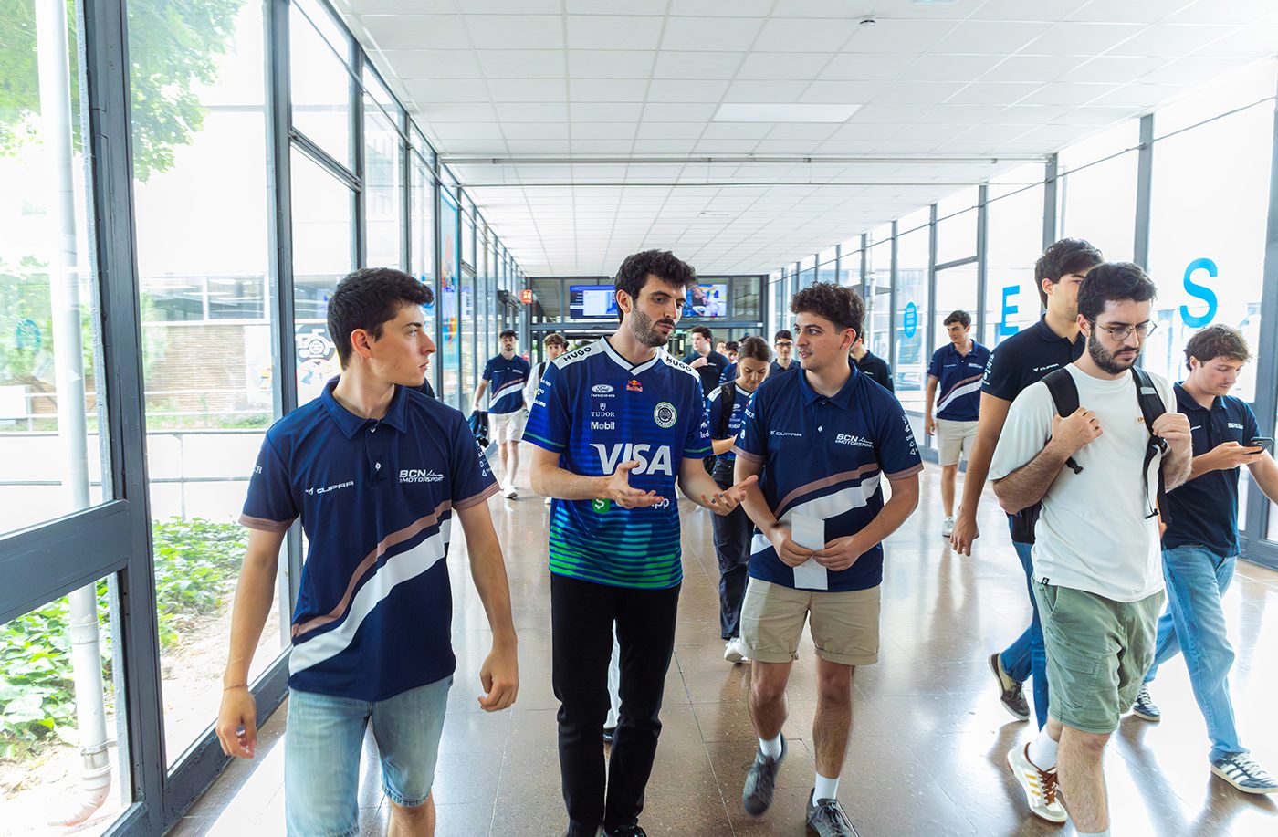 VCARB Formula 1 engineer walking with UPC Motorsport students during a career event at ETSEIB in Barcelona as part of Yugo Formula 1 Week.