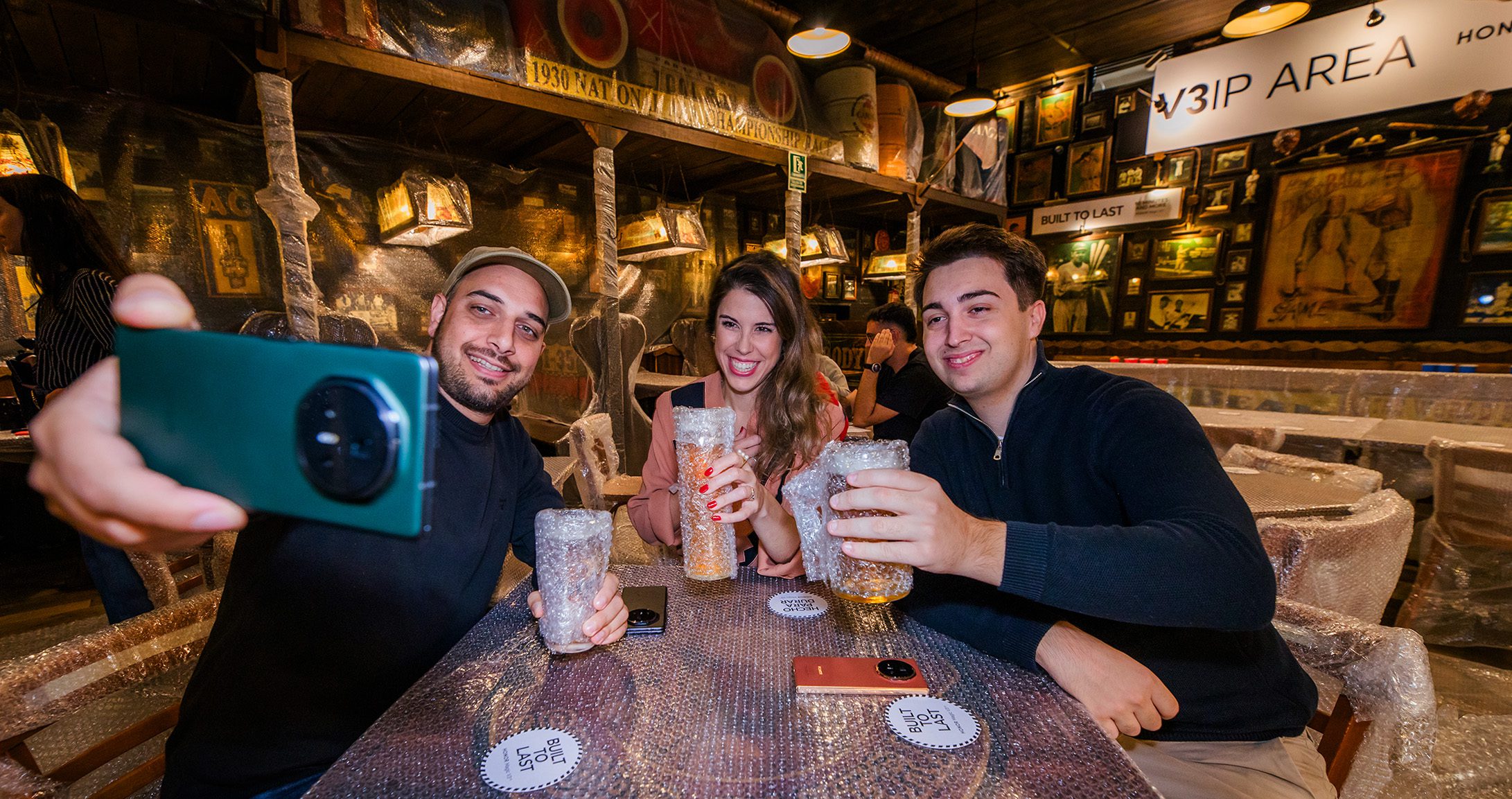 HONOR Smartphone Brand Activation | Barcelona Guests taking a selfie with a HONOR smartphone during a brand activation event at a bubble wrap-themed bar in Barcelona.