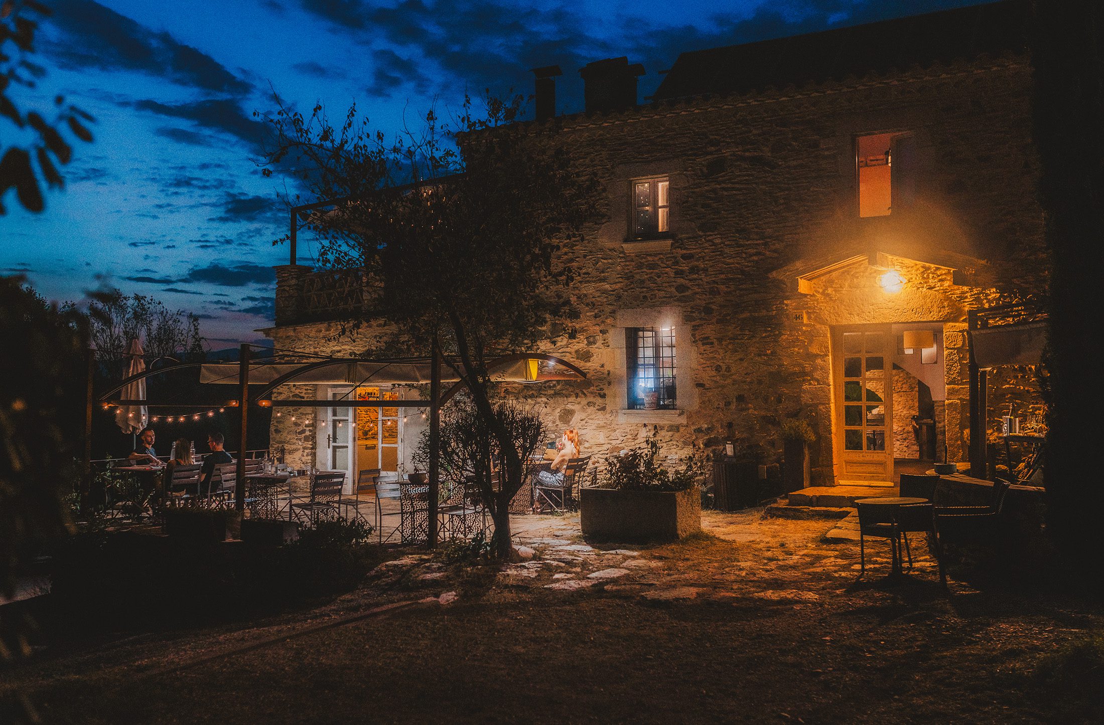 Restaurant Mirador Can Pi illuminated at night in the Girona countryside.